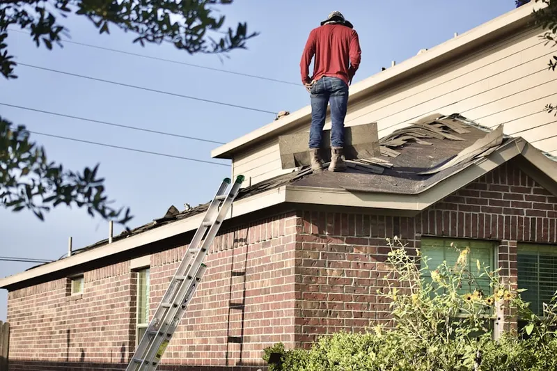 Professional roofer working on a residential roof in Abrams